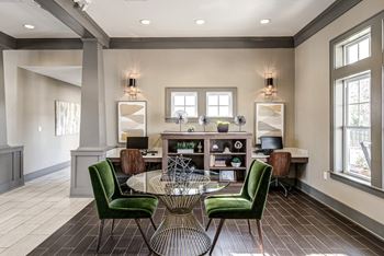 A living room with a round table and green chairs